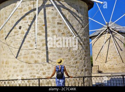 Junge Frau, die vor der Windmühle steht Stockfoto