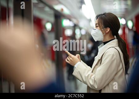 Die junge Frau stand in einer Maske auf dem U-Bahnsteig Stockfoto