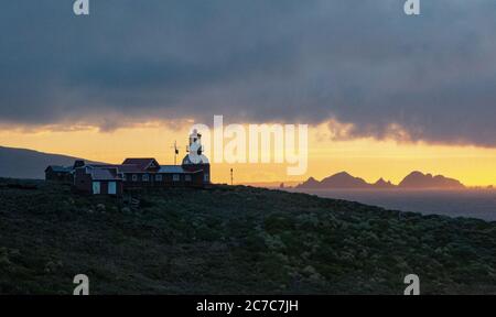 Schöne Aufnahme von Gebäuden und einem Leuchtturm auf einem Berg Unter einem wolkenlosen Himmel am Kap Horn Stockfoto