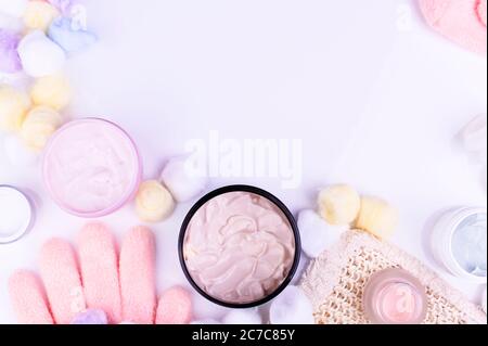Beauty, Spa-Behandlungen im Salon und zu Hause. Creme, Masseur, Öl, Handschuhe zum Befeuchten der Hände auf einem weißen Tisch und Palmblätter. Layout, Draufsicht. Freier Speicherplatz für Text. Hochwertige Fotos Stockfoto