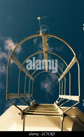 Niedriger Winkel vertikale Aufnahme einer weißen metallischen Leiter gehen Oben mit dem Himmel im Hintergrund Stockfoto