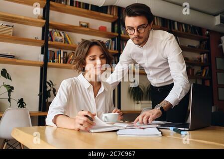 Junge attraktive Kollegen arbeiten gerne gemeinsam im Büro an einem neuen Projekt Stockfoto