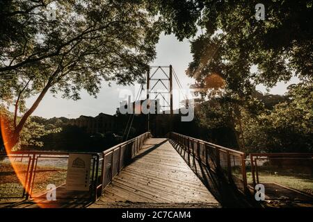 Horizontale Aufnahme einer Seilbrücke über einen Fluss in Ein Park Stockfoto