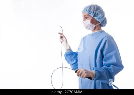 Ärztin oder Krankenschwester, die einen blauen sterilen Anzug oder einen blauen Kittel mit Ablationskatheter für einen Herzvorgang trägt Stockfoto