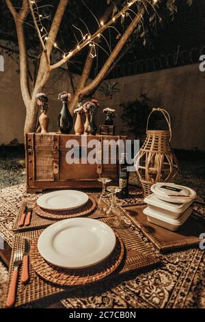 Nahaufnahme der hölzernen Brust, mit den Vasen darauf, dem Strohkorb, den Tellern und den Weingläsern Stockfoto