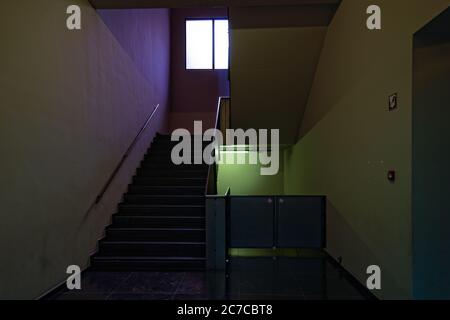 Innenaufnahme eines schwach beleuchteten Treppenhauses mit der Treppe S führt zu einem Fenster Stockfoto