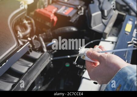 Ölstand im Fahrzeug auf Motorhintergrund prüfen Stockfoto