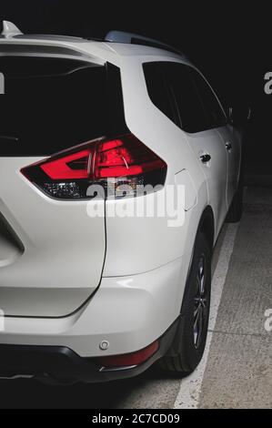 Rückseite Ansicht des weißen modernen SUV-Autos in schwarzem Hintergrund Stockfoto