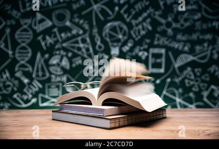 Vor der Tafel zeichnen Bücher und Gläser auf den Tisch Stockfoto