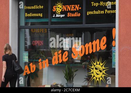 16. Juli 2020, Mecklenburg-Vorpommern, Torgelow: Der Schriftzug "ab in Sonne" steht auf dem Fenster eines Sonnenbads. Die Stadt liegt an der unteren Uecker im Bereich der Ueckermünder Heide zwischen den Städten Pasewalk und Ueckermünde. Die 1281 erstmals erwähnte Kleinstadt hat heute über 9,000 Einwohner und wurde einst als Handelszentrum am Zusammenfluss von Uecker und Randow gegründet. Viele Wohnungen und Geschäfte in der Altstadt sind heute leer. Die traditionelle Gießerei, die vor allem für ihre mehrere Tonnen schweren Komponenten für große Windenergieanlagen und bekannt ist Stockfoto