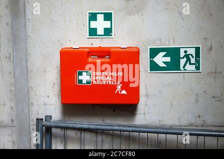 Nordrhein-Westfalen, Deutschland - erste Hilfe-Kasten an einer Betonwand neben einem Schild Notausgang auf einer Baustelle, symbolisches Bild der Belegung Stockfoto