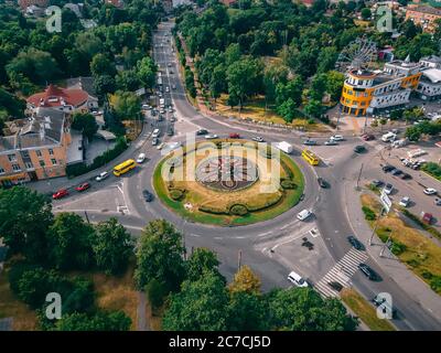 Luftaufnahme der Kreisstraße mit kreisförmigen Autos in kleinen europäischen Stadt am Sommernachmittag, Kiew Region, Ukraine Stockfoto