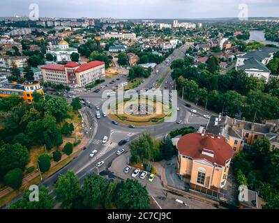 Luftaufnahme der Kreisstraße mit kreisförmigen Autos in kleinen europäischen Stadt am Sommernachmittag, Kiew Region, Ukraine Stockfoto