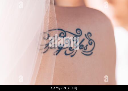 BALI, INDONESIEN - 23. Dez 2013: Tattoo auf dem Rücken einer Braut, das ihre Hingabe zur Ehe zeigt Stockfoto