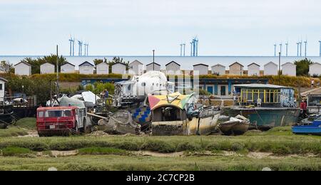 Brighton UK 16. Juli 2020 - Bunte Hausboote auf Grund im Fluss Adur bei Shoreham in der Nähe von Brighton mit der Rampion Offshore Wind Farm am Horizont an einem warmen hellen Tag in Sussex als wärmere sonnige Wetter für später in der Woche und am Wochenende in ganz Großbritannien prognostiziert : Credit Simon Dack / Alamy Live News Stockfoto