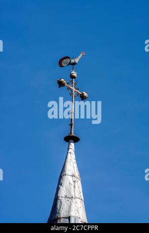 Wetterfahne auf einem Kirchturm vor einem klaren blauen Himmel in einer malerischen Stadt, Auvergne, Frankreich Stockfoto