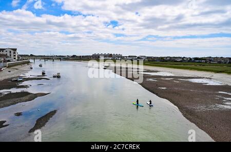 Brighton UK 16. Juli 2020 - Paddlebarder fahren entlang des Flusses Adur in Shoreham bei Brighton an einem warmen Tag in der Nähe von Brighton, da wärmeres sonniges Wetter für später in der Woche und am Wochenende in ganz Großbritannien prognostiziert wird : Credit Simon Dack / Alamy Live News Stockfoto