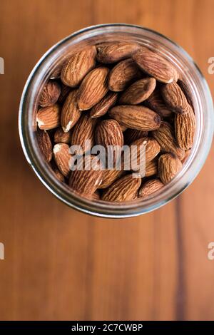 Vertikale selektive obenliegende Schuss von Mandeln in einem Glas Stockfoto