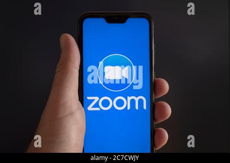 Der Bildschirm eines Smartphones mit Zoom Cloud Meeting Video Konferenz App Logo auf schwarzem Hintergrund Stockfoto