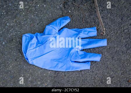 Gebrauchte weiße Gummihandschuhe auf dem Zaun übersät. Die Leute haben ihre Handschuhe übersättert. Coronavirus-Pandemie Stockfoto