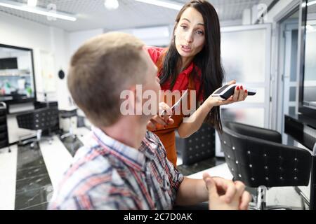 Frau Friseur diskutieren Haarschnitt mit Client. Stockfoto