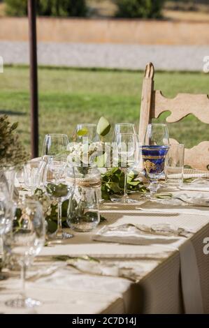 Vertikale Aufnahme von Weingläsern und Blumensträuße auf einem Dekorierter Tisch Stockfoto