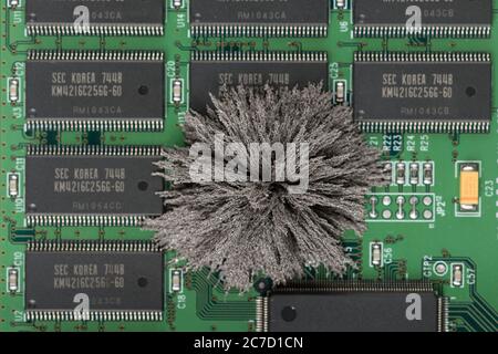 Magnetfelder, die durch Mac-Computer-PC-Boards passieren, wo Eisenspäne unsichtbare Feldlinien zeigen, die von einem einzigen Pol permanentem Neodym kommen Stockfoto