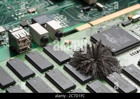 Magnetfelder, die durch Mac-Computer-PC-Boards passieren, wo Eisenspäne unsichtbare Feldlinien zeigen, die von einem einzigen Pol permanentem Neodym kommen Stockfoto