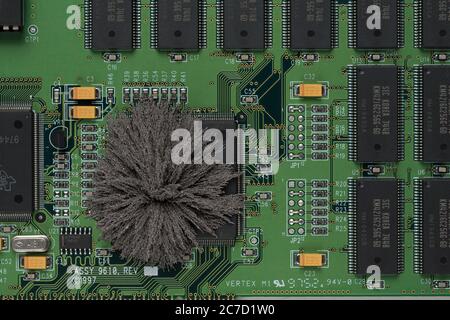 Magnetfelder, die durch Mac-Computer-PC-Boards passieren, wo Eisenspäne unsichtbare Feldlinien zeigen, die von einem einzigen Pol permanentem Neodym kommen Stockfoto
