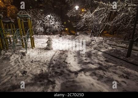 Horizontale Aufnahme eines Spielplatzes in einem Park in der Nähe von an Apartment-Komplex im Schnee in Moskau bedeckt Stockfoto