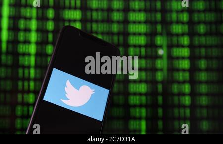 Viersen, Deutschland - 9. Juli. 2020: Blick auf Handy mit twitter-Logo von Hand halten. Bildschirm mit Tunnel von binären Code-Nummern Hintergrund.(selektiv Stockfoto