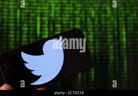 Viersen, Deutschland - 9. Juli. 2020: Blick auf Handy mit twitter-Logo von Hand halten. Bildschirm mit Tunnel von binären Code-Nummern Hintergrund.(selektiv Stockfoto