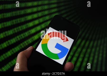 Viersen, Deutschland - 9. Juli. 2020: Ansicht auf Handy mit google-Logo von Hand halten. Bildschirm mit Tunnel von binären Code-Nummern Hintergrund.(selektive f Stockfoto
