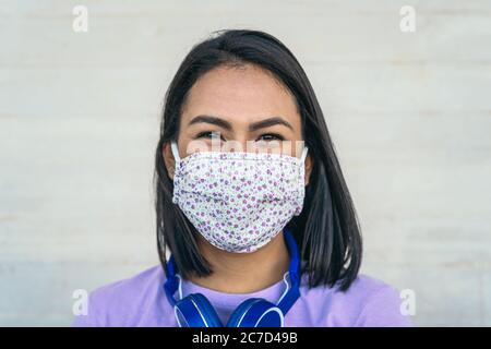 Junge Frau trägt Gesichtsmaske Porträt - Latein Mädchen mit Schutzmaske zur Verhinderung der Ausbreitung von Corona-Virus Stockfoto