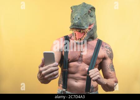 Senior Mann nimmt Selfie mit Smartphone, während Dinosaurier-Maske - Reife Social Influencer Spaß mit mobilen App Stockfoto
