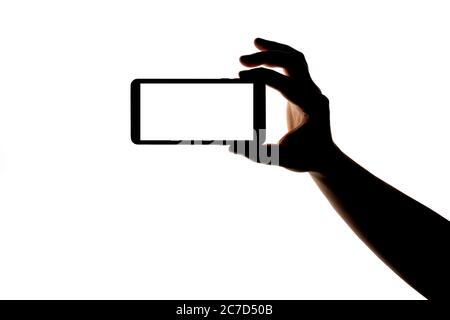 Silhouette der Hand mit Smartphone Aufnahme Bild isoliert auf weißem Hintergrund. Bildschirm mit Kopierbereich. Leer oder Modell für Design. Stockfoto