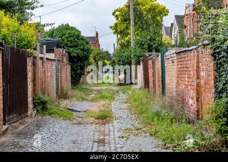 Ungepfiß und schmutzige Hintergassen zwischen Wohnimmobilien in der Abington Gegend von Northampton, England, Großbritannien. Stockfoto