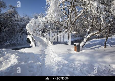 Die horizontale Aufnahme der Brücke, die im Schnee über dem Fluss im Winter in Moskau, Russland bedeckt ist Stockfoto