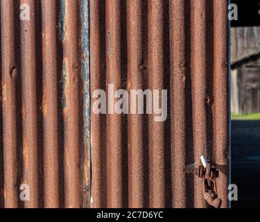Rostige Metalltür mit gewelltem, welligem Muster, Hintergrund und Textur Stockfoto
