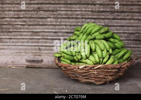 Nahaufnahme von vielen leckeren grünen Bananen in Ein Korb auf dem Boden in Indien Stockfoto