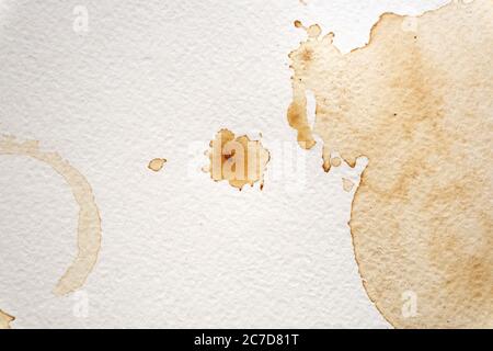 Abstrakte flüssige Tropfen spritzen braunen Kaffee auf einem weißen Texturpapier Hintergrund für Aquarell. Künstlerische Dekoration oder Hintergrund. Banner für Text, Grunge Element. Stockfoto