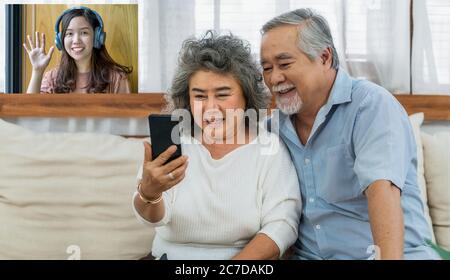 Asiatische paar Großeltern nehmen Video-Anruf zu Enkelin Frau mit Glück Gefühl von Handy im Haus, lange leben und ältere Gesellschaft, warm fam Stockfoto