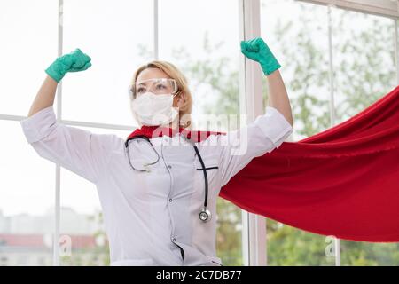 Arzt in Superhelden Anzug auf Verteidigung vor Virus-Pandemie auf dem Fenster stehen Stockfoto