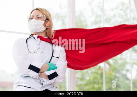 Arzt in Superhelden Anzug auf Verteidigung vor Virus-Pandemie auf dem Fenster stehen Stockfoto