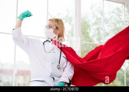 Arzt in Superhelden Anzug auf Verteidigung vor Virus-Pandemie auf dem Fenster stehen Stockfoto