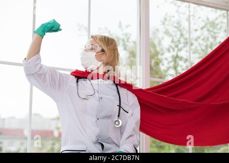 Arzt in Superhelden Anzug auf Verteidigung vor Virus-Pandemie auf dem Fenster stehen Stockfoto