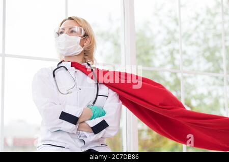 Arzt in Superhelden Anzug auf Verteidigung vor Virus-Pandemie auf dem Fenster stehen Stockfoto