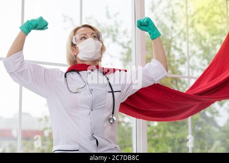 Arzt in Superhelden Anzug auf Verteidigung vor Virus-Pandemie auf dem Fenster stehen Stockfoto