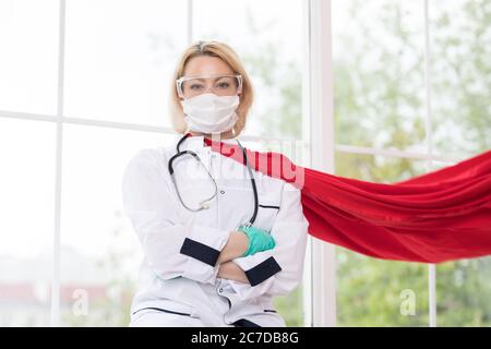 Arzt in Superhelden Anzug auf Verteidigung vor Virus-Pandemie auf dem Fenster stehen Stockfoto