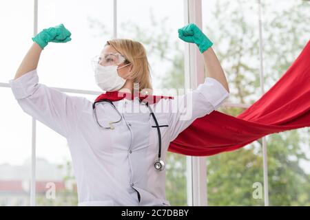 Arzt in Superhelden Anzug auf Verteidigung vor Virus-Pandemie auf dem Fenster stehen Stockfoto